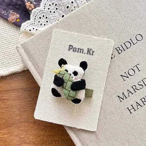 Close-up of cute 3D plush panda hair clip with green bamboo on aesthetic gift card
