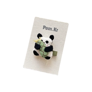 Cute plush panda hair clip with green embroidered rice dumpling on white card display