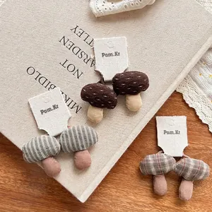 Three pairs of handmade 3D fabric mushroom hair ties with plaid and polka dot patterns