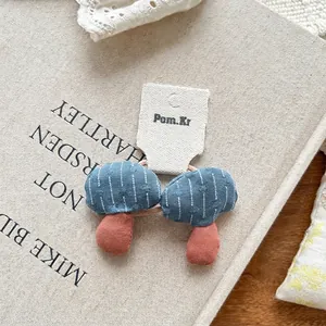 Detailed close-up of handmade blue gingham and polka dot fabric mushroom hair ties set