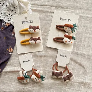Lindas pinzas bordadas de zorro y conejo con gomas a juego sobre fondo de lino
