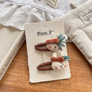 Detalle de horquillas bordadas de conejo y zanahoria sobre un fondo artístico
