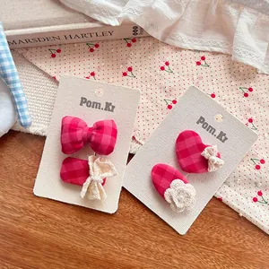 Détail de pinces à cheveux à carreaux rouges avec dentelle et fleur en crochet doux