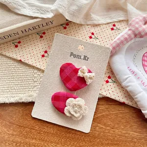 Détail de barrettes à carreaux rouges faites main avec dentelle et perles