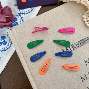 Close-up of matte candy-colored water-drop snap clips set on a canvas fabric background