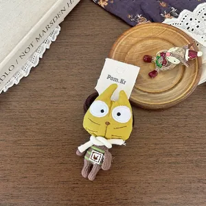 Détail de l'accessoire de cheveux chat en peluche jaune sur carte blanche sur table en bois