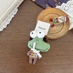 Gros plan d'un chouchou grenouille tricoté vert avec un haut rayé sur bois vintage