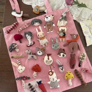 Cute handmade cartoon fabric brooches with animal and creative shapes on a pink bag