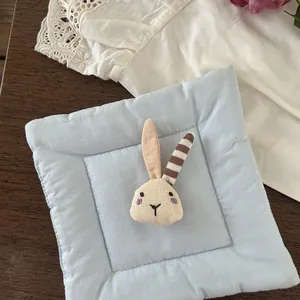 Detail of light blue fabric accessory with cute 3D rabbit head and embroidery texture