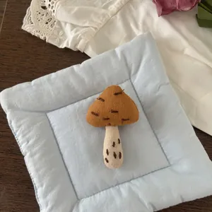 Detailed close-up of handmade mushroom fabric brooch featuring caramel brown linen texture
