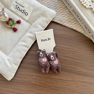 Détail de chouchous ours marron avec broderie cœur et élastiques pour filles