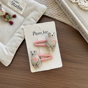 Détail de barrettes à cheveux ourson brodées sur un fond de texture bois chaleureux
