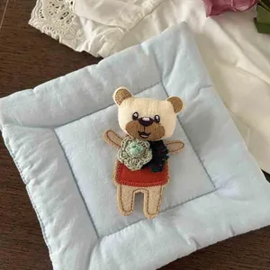Handmade cute teddy bear plush brooch with red sweater and green flower embroidery detail