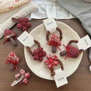 Set di accessori per capelli in tessuto con fiori e funghi su un piatto di ceramica