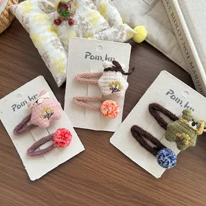 Détail de barrettes à cheveux étoile en tricot faites main et clips à pompons