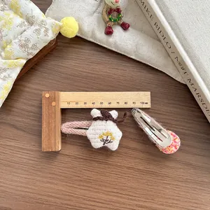 Détail de barrettes à cheveux coréennes avec broderie florale et pompon rose sur bois