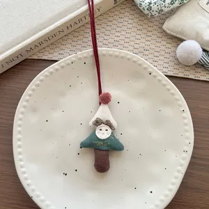Dettaglio di una collana artigianale in tessuto ad albero di Natale con personaggio