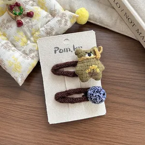 Détails de l'ours en tricot mignon et des pompons colorés sur l'ensemble de barrettes