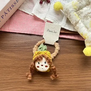 Close-up of cute handmade plush doll hair tie featuring a girl in a yellow pineapple outfit