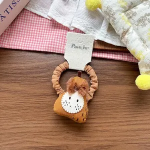 Close-up of cute fruit fabric hair tie with brown pleated band and cartoon pear charm