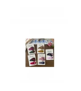 Détail de barrettes à cheveux en tissu fleuri avec nœud et détails de broderie