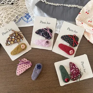 Lot de barrettes à fleurs style coréen pour enfants présentées sur une table en bois
