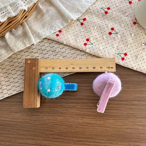 Detailed close-up of plush hair clips with blue stars and pearls on a lace background