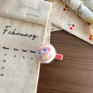 Detail of cute wool felt ice cream hair clip with stars on soft pink velvet base