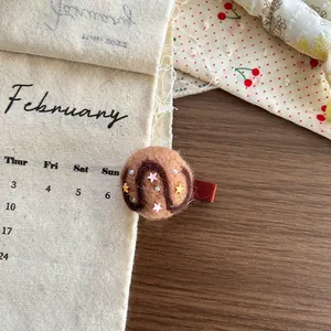 Detail of wool felt hair clip with star sequins and small pearls on a red metal duckbill clip