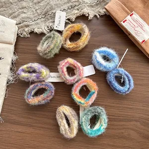 Détail de chouchous colorés en peluche sur fond en bois avec esthétique automnale douce