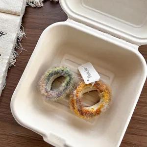 Gros plan de chouchous en peluche bicolores gris-vert et orange-brun à texture tissée