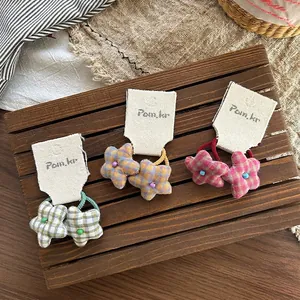 Three-piece star-shaped plaid fabric hair ties with beads on dark wooden background