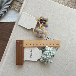 Detailed view of plaid star-shaped fabric hair ties in yellow and green on a canvas card