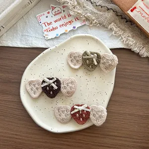 Gros plan de pinces à cheveux fraises en tricot vert, marron et rouge sur assiette