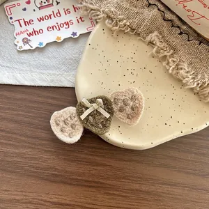 Détail de barrettes à cheveux fraises crochetées à la main sur un plateau décoratif
