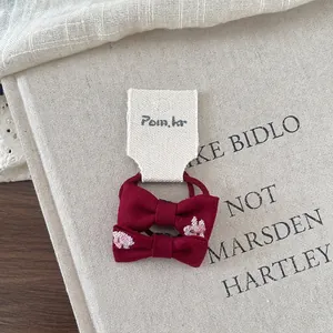 Detail of red bow hair clip and elastic tie set with cute pink animal embroidery