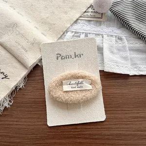 Detail von Plüsch-Lammwolle-Haarspange mit handgefertigtem Etikett auf Dekorkarte