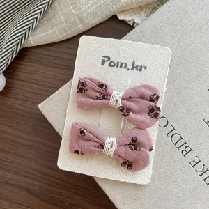 Dettaglio di fermagli per capelli a fiori rosa con pizzo bianco su carta ruvida