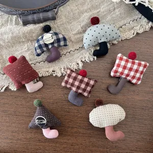 Handmade fabric brooch pins with colorful pompoms and cute checkered patterns on linen