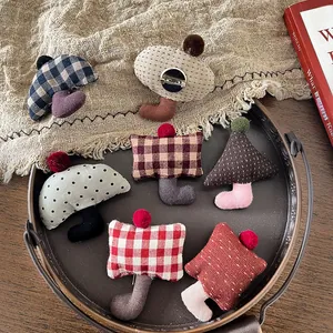 Close-up of handmade fabric brooches with colorful pom-poms and metal pin fasteners