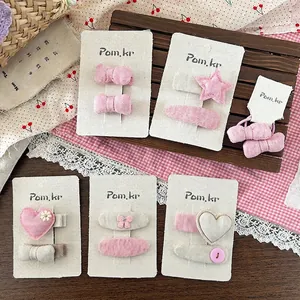 Süßes Stoff-Haarspangen-Set mit Herzen und Sternen in Rosa und Creme auf Displaykarte