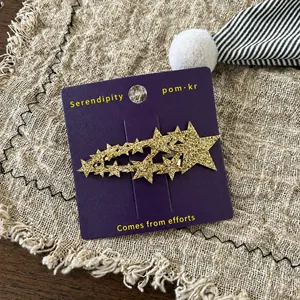 Detail von koreanischem goldenem Glitzer-Stern-Haarclip auf lila Displaykarte