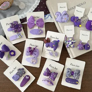 Detailaufnahme von violetten Stoff-Haarspangen und handgestrickten Blumen-Accessoires