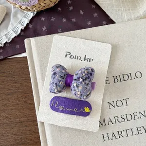 Nahaufnahme von lila Blumen-Schleifen-Haarspangen und besticktem Haarclip-Set