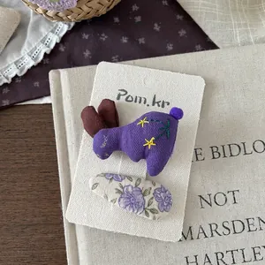 Detail von lila Hasen- und Blumen-Stoff-Haarclip-Set auf weißer Displaykarte
