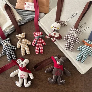 Handmade cute plaid teddy bear and rabbit fabric keychain charms on vintage wood surface