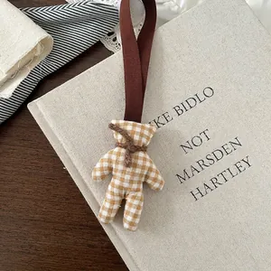 Detail of cute yellow gingham fabric bear charm with ribbed ribbon and neck tie