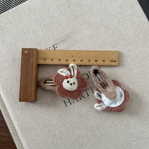 Details von braunen gestrickten Blumenhaarklammern mit süßem Kaninchen für Kinder