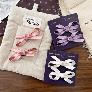 Three-pack of satin bow hair clips for girls in pink, purple, and cream white colors