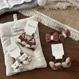Détails des barrettes en tissu marron avec broderies de renard et d'ours